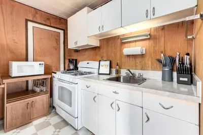 a kitchen with white cabinets and a sink at Huckleberry Lodge Mountain Getaway Near Banff in Canmore