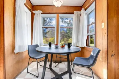 a table and chairs in a room with a window at Huckleberry Lodge Mountain Getaway Near Banff in Canmore