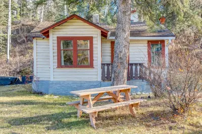 a wooden picnic table in front of a house at Huckleberry Lodge Mountain Getaway Near Banff in Canmore