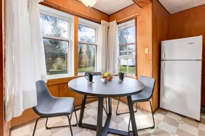 a kitchen with a table and chairs and a refrigerator at Huckleberry Lodge Mountain Getaway Near Banff in Canmore