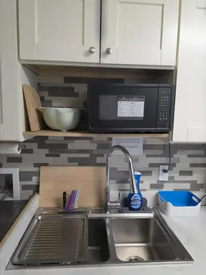 a kitchen counter with a sink and a microwave at Maplewood Hostel in Vancouver