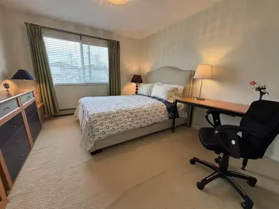 a bedroom with a bed and a desk and a chair at Vancouver Richmond Villa 33 in Richmond