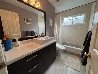 a bathroom with a sink and a toilet and a mirror at Vancouver Richmond Villa 33 in Richmond