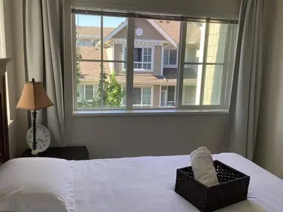 a bedroom with a bed with a window and a basket of towels at Vancouver Richmond Villa 33 in Richmond