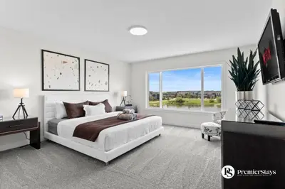 a bedroom with a large bed and a large window at Luxurious Detached House with Private Garage, Lake View, Central AC & More in Airdrie