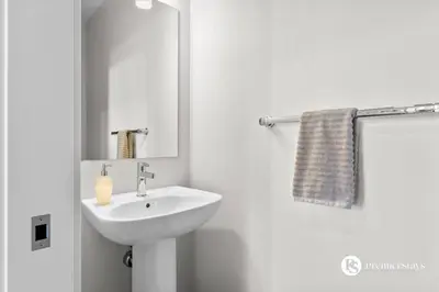 a white bathroom with a sink and a mirror at Luxurious Detached House with Private Garage, Lake View, Central AC & More in Airdrie