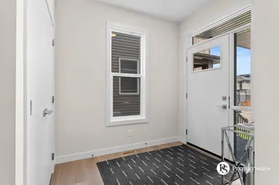 a hallway with a door and a window at Luxurious Detached House with Private Garage, Lake View, Central AC & More in Airdrie