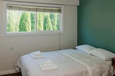 a bedroom with a bed with two towels on it at Serene 3BR Cabin on 8 Acre Farm in Mission City