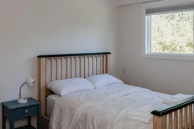 a bedroom with a large bed with a window at Serene 3BR Cabin on 8 Acre Farm in Mission City