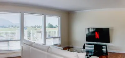 a living room with a white couch and a tv at Serene 3BR Cabin on 8 Acre Farm in Mission City