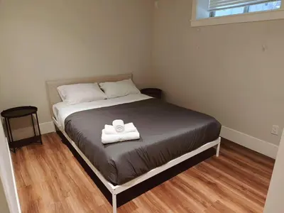 a bedroom with a bed with a towel on it at Bright 3-Bedroom Basement Suite with Separate Entrance in Burnaby