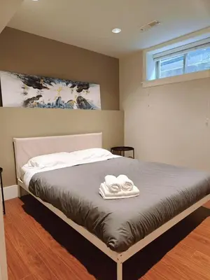 a bedroom with a bed with two towels on it at Bright 3-Bedroom Basement Suite with Separate Entrance in Burnaby
