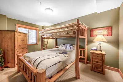 a bedroom with a bunk bed and a night stand at Treetops Ski Luxury Townhouse in Big White