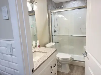 a bathroom with a shower and a toilet and a sink at Annas Suites Rental in Bélanger