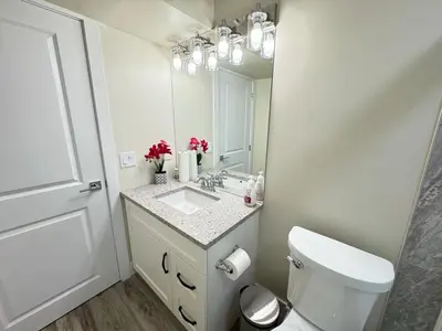 a bathroom with a sink and a toilet and a mirror at Annas Suites Rental in Bélanger