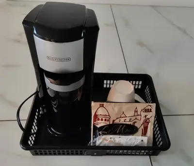 a black and white coffee maker in a basket at Queens Suite in West Vancouver