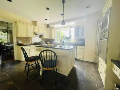 a kitchen with two chairs and a island in it at \u6e29\u54e5\u534e\u6e29\u897f\u522b\u588534 in Vancouver