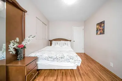 a bedroom with a bed and a vase of flowers at Dreamy Garden Arch Spot Cozy 3Bedroom Villa near the Beach in Surrey