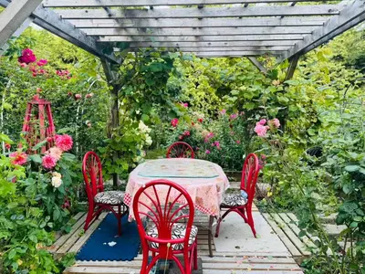 a table and chairs with a table and flowers at Dreamy Garden Arch Spot Cozy 3Bedroom Villa near the Beach in Surrey