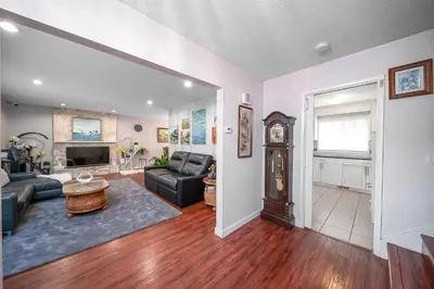 a living room with a couch and a clock at Dreamy Garden Arch Spot Cozy 3Bedroom Villa near the Beach in Surrey