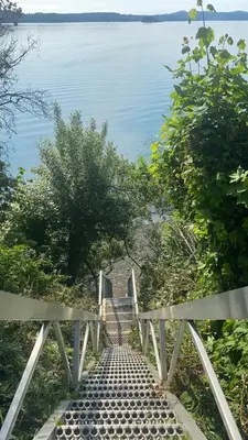 a stairway leading down to the water with a bench at Stunning oceanfront home 4br3b sunrise beachcombing near Bamberton Park in Mill Bay
