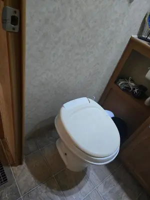 a bathroom with a white toilet in a room at Family RV in a farm in Nanoose Bay