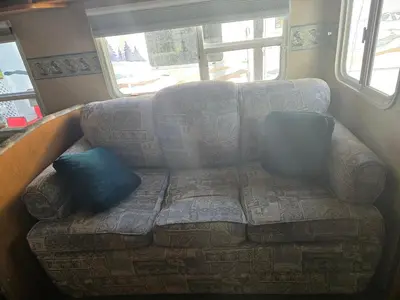 a couch sitting in a living room with a window at Family RV in a farm in Nanoose Bay