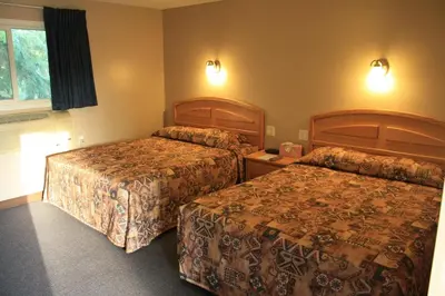 a hotel room with two beds and a window at Lamplighter Inn in Three Hills