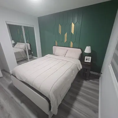 a bedroom with a large bed with a green wall at The Walkout at the Ravine in Edmonton