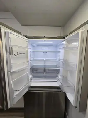 an empty refrigerator with its door open in a kitchen at The Walkout at the Ravine in Edmonton