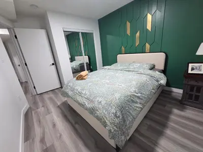 a bedroom with a bed and a green wall at The Walkout at the Ravine in Edmonton