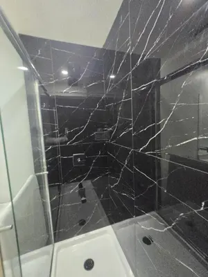 a bathroom with a shower with a glass door at The Walkout at the Ravine in Edmonton