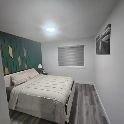 a bedroom with a bed and a painting on the wall at The Walkout at the Ravine in Edmonton