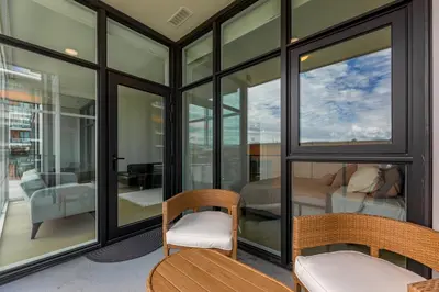 a room with glass windows and a bedroom at Gyro Beach Vacations in Kelowna
