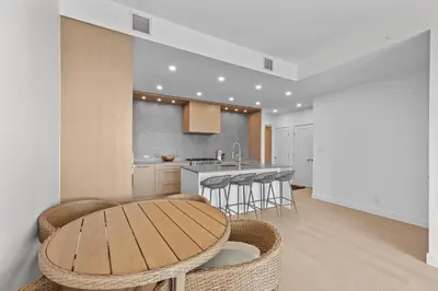 a kitchen with a wooden table and stools at Gyro Beach Vacations in Kelowna