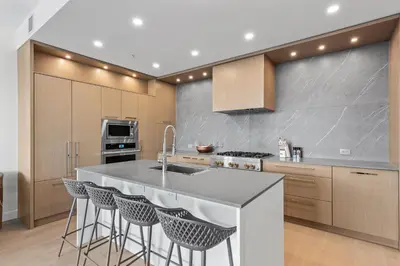 a kitchen with a sink and a counter with bar stools at Gyro Beach Vacations in Kelowna