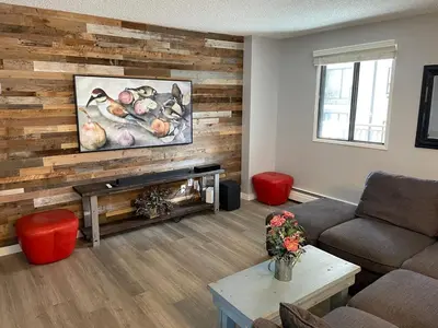a living room with a wooden accent wall at YYC HiddenGem in Calgary