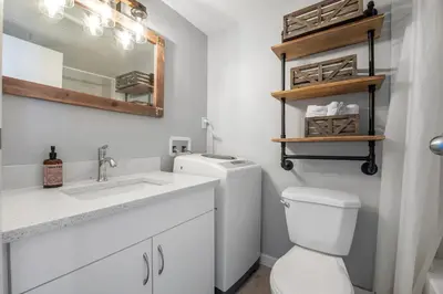 a bathroom with a toilet and a sink and a mirror at YYC HiddenGem in Calgary