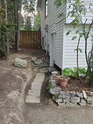 a backyard with a stone walkway next to a house at The Hilltop in Whitehorse