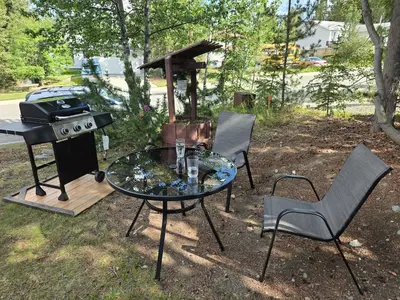 a table and chairs and a grill and a table and chairs at The Hilltop in Whitehorse