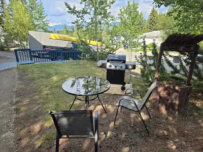 a patio with a table and chairs and a grill at The Hilltop in Whitehorse