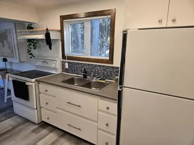 a kitchen with a sink and a refrigerator at The Hilltop in Whitehorse