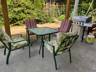 three chairs and a table and a grill on a patio at Angie house in Nanaimo