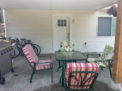 a patio with chairs and a table and some bikes at Angie house in Nanaimo