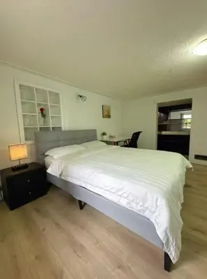 a bedroom with a large white bed and a desk at Vancouver Burnaby Villa 36 in Burnaby