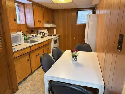 a kitchen with a table with chairs and a microwave at Vancouver Burnaby Villa 36 in Burnaby