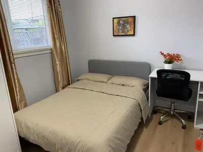 a bedroom with a bed and a desk and a chair at Vancouver Burnaby Villa 36 in Burnaby