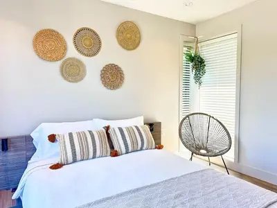 a bedroom with a white bed and a chair at Vancouver Westside Villa 37 in Vancouver