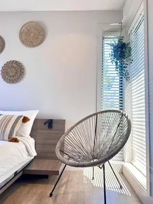 a bedroom with a chair and a bed and a window at Vancouver Westside Villa 37 in Vancouver