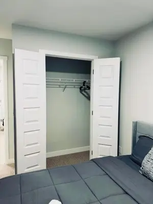 a bedroom with a closet with a white door at Cozy house with 4 Bedrooms 3 Full bath and 1 half bath in Calgary